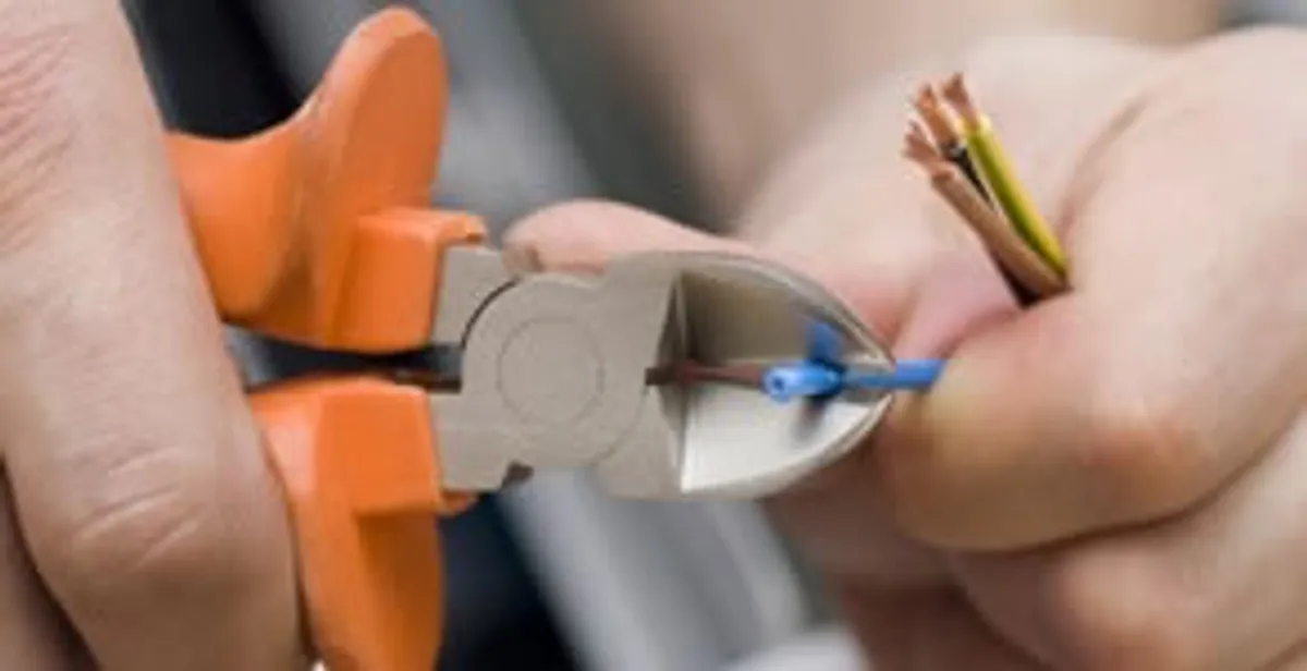 licensed electrician performing precise wire cutting and preparation during electrical service in Peoria, IL