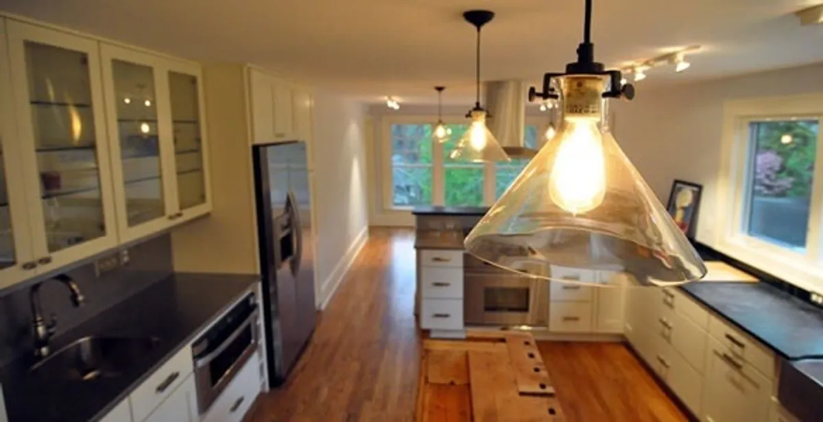 Residential electrician installing modern indoor light fixture in a home in Peoria, IL